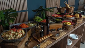 A buffet table with various food items and utensils.
