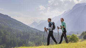 Two people hiking in a mountainous area with a clear sky.