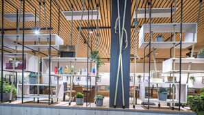 A modern interior with wooden beams, shelves with plants, and a central column with ropes. - JUFA Hotel Wipptal (Steinach am Brenner)