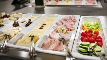 Un buffet con diversi cibi, tra cui formaggi, salumi e verdure.