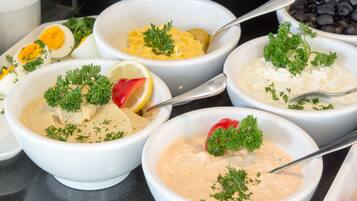 A variety of dishes including a bowl of creamy dip, a bowl of rice, and a bowl of black beans.