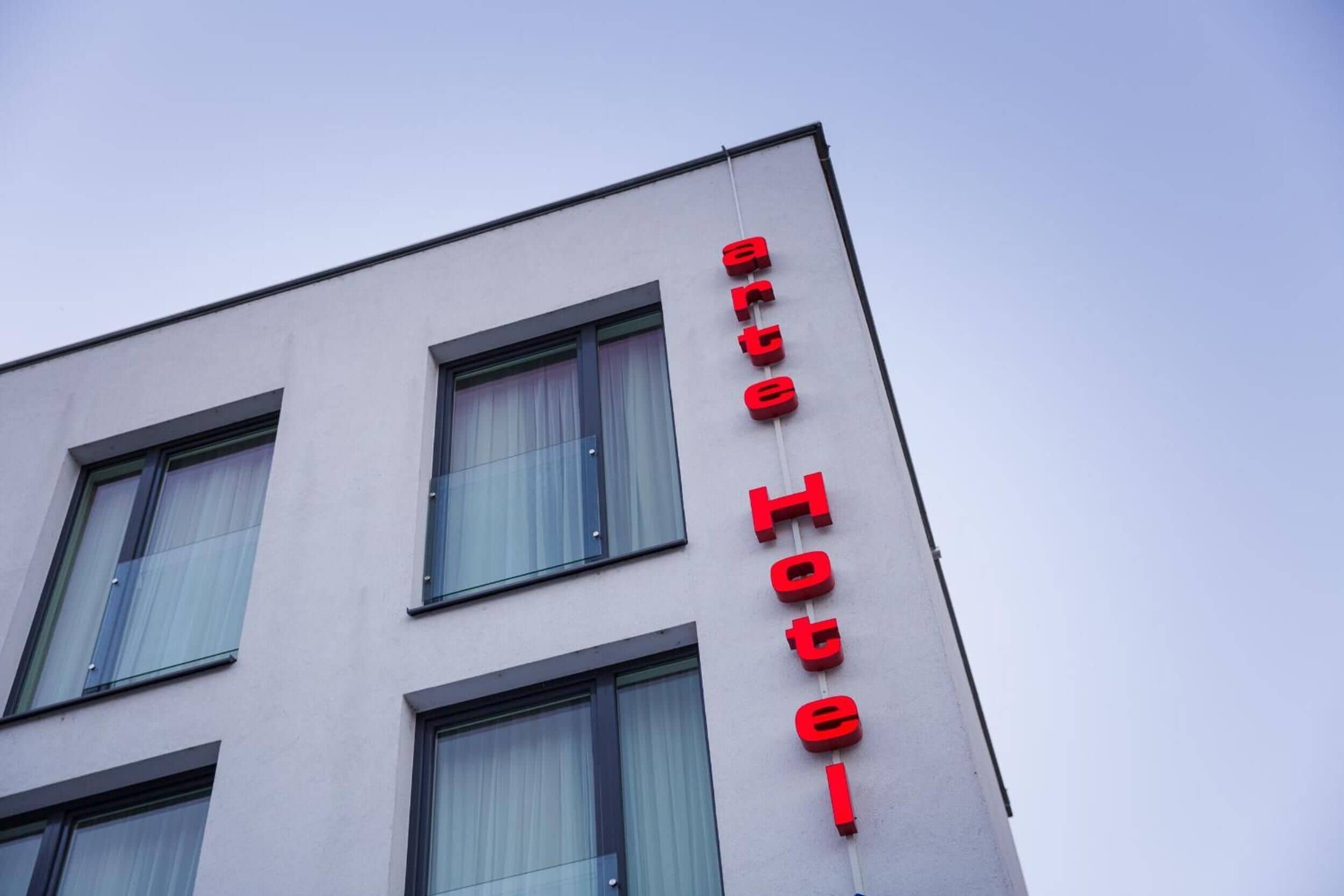 A building with a sign reading "arte Hotel" in red letters.