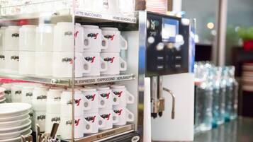 Una cafetera con recipientes etiquetados para distintos tipos de café y leche.