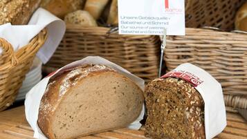 A display of various breads in baskets, including a loaf with a white label.