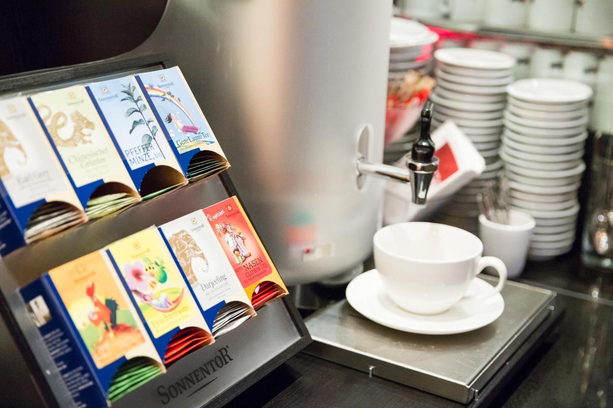 A coffee machine with a selection of coffee pods and a cup on a tray.
