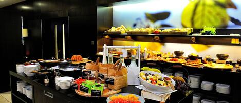 A buffet with various food items and condiments.
