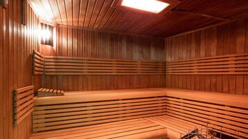 A sauna with wooden benches and a sloped ceiling.