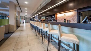 A modern bar area with high stools and a counter displaying various bottles. - Quality Hotel Ostrava City (Ostrava)