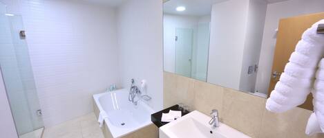 Un baño moderno con cabina de ducha de vidrio, tocador doble y un espejo grande.
