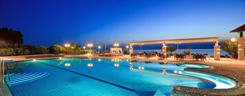 Una piscina al aire libre de temporada, sombrillas