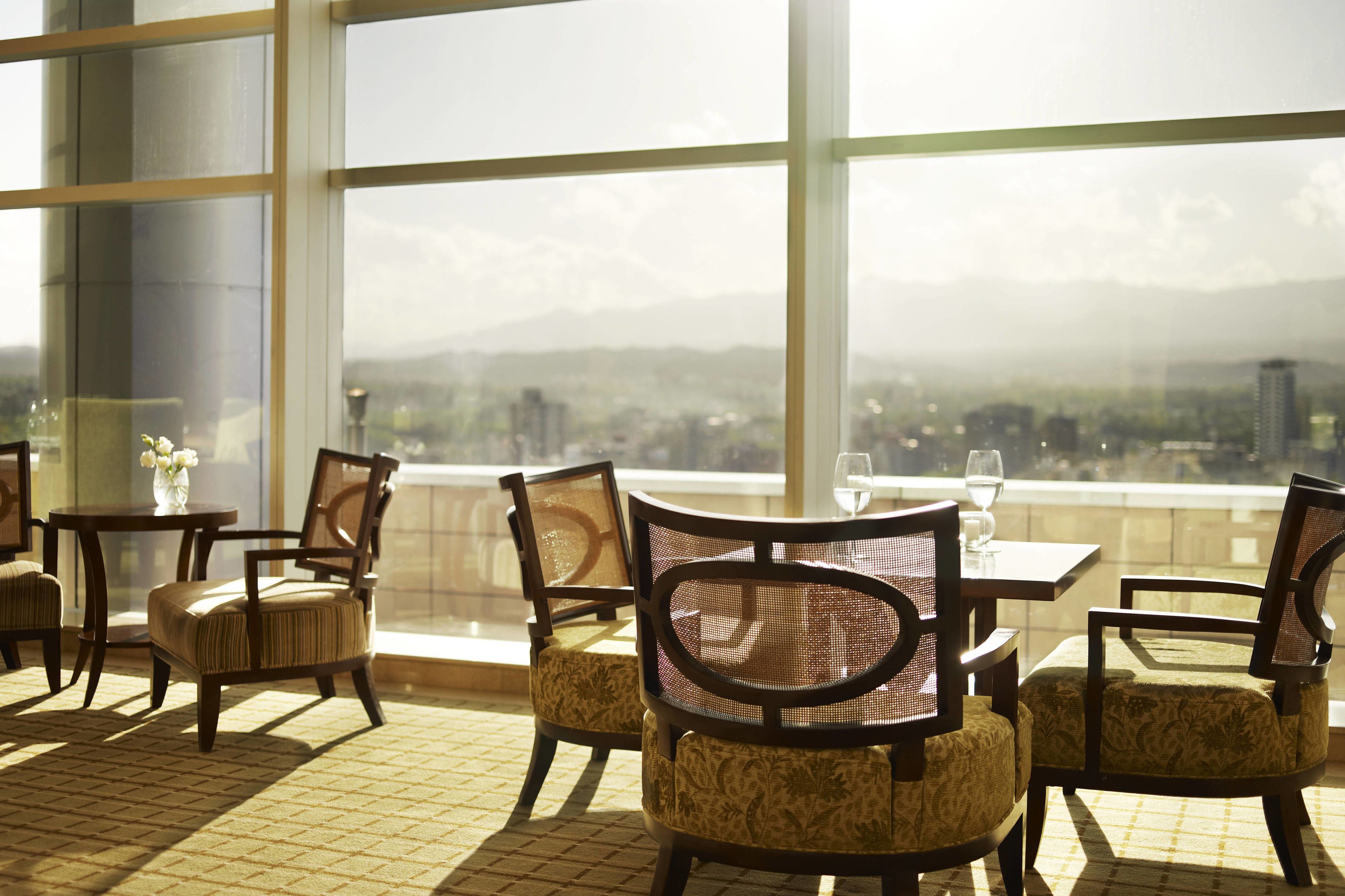Comedor con vista a un paisaje urbano a través de amplios ventanales.