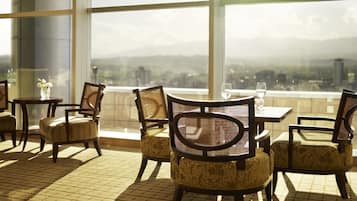 A dining area with a view of a cityscape through large windows.