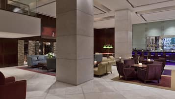 A lobby with a bar area, seating arrangements, and a stone accent wall.