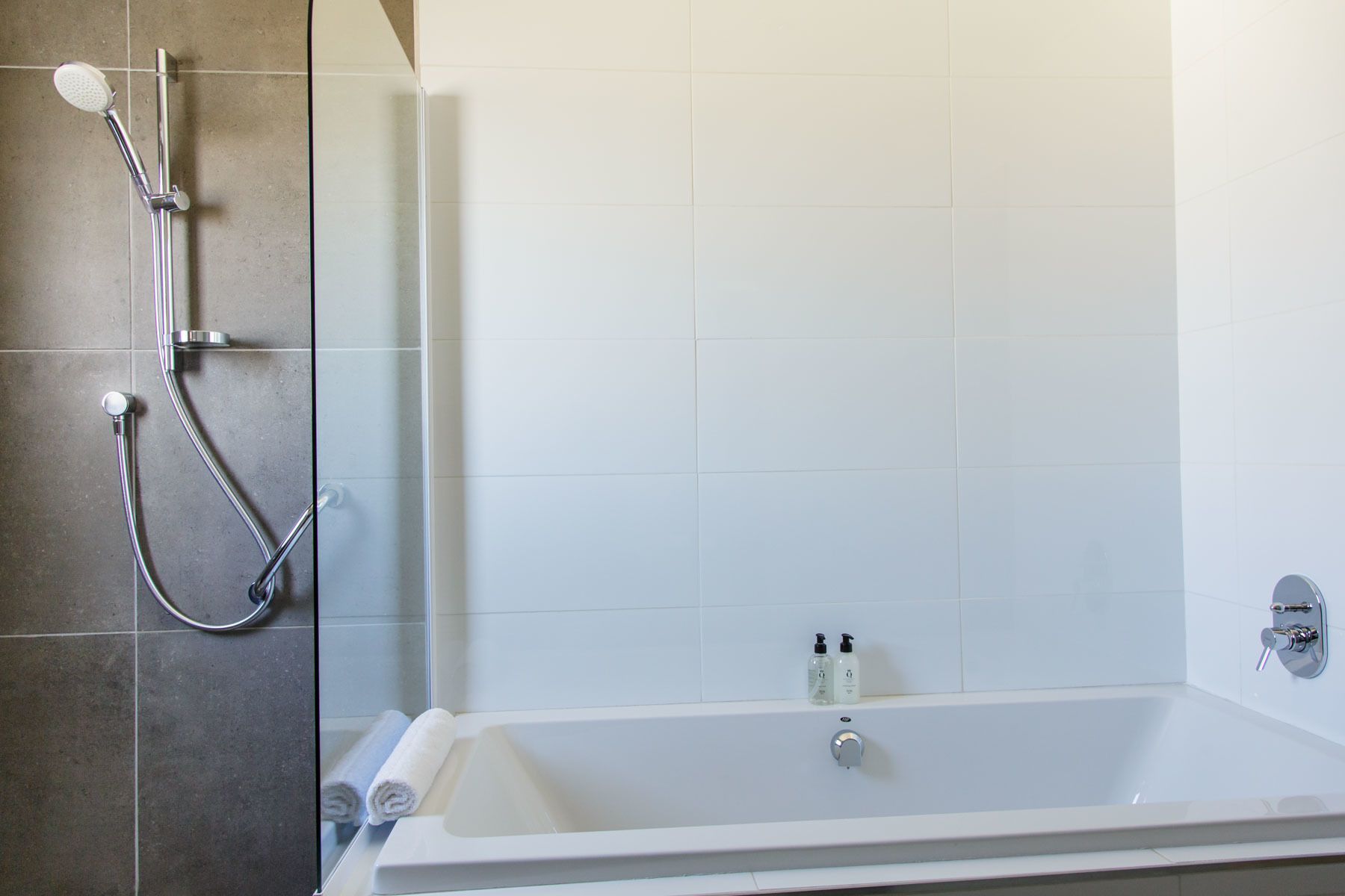 A bathroom with a bathtub, a shower, and a glass-enclosed shower area.