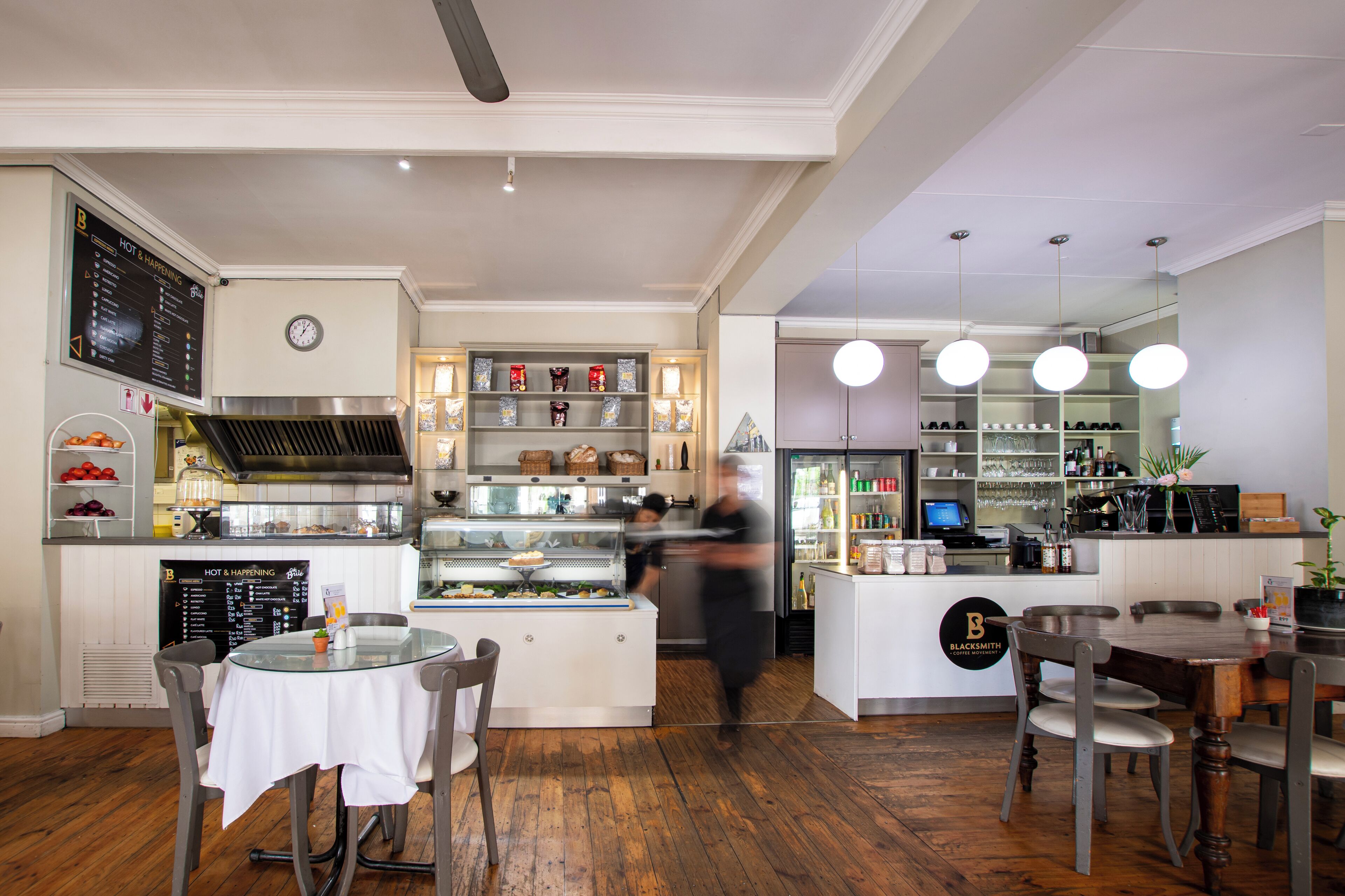 A restaurant interior with a central counter, seating area, and a bar.