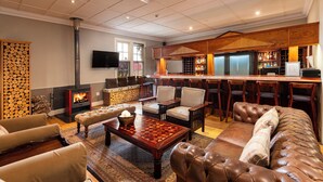 Un salón amplio con chimenea, sofás de cuero y una mesa de centro de madera.