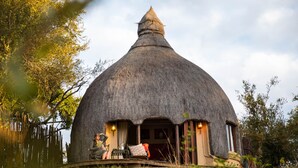 A thatched-roof house with a small porch and a single window. - Hoyo Hoyo Safari Lodge (Bushbuckridge)