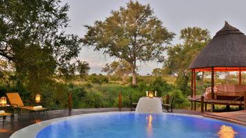 Una piscina al aire libre, sillones reclinables de piscina