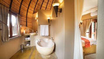 Une salle de bain avec une grande baignoire, un lavabo et un porte-serviettes.