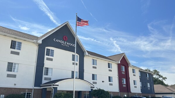 Un hôtel au design moderne, avec un drapeau américain bien visible, flottant au sommet d’un mât.