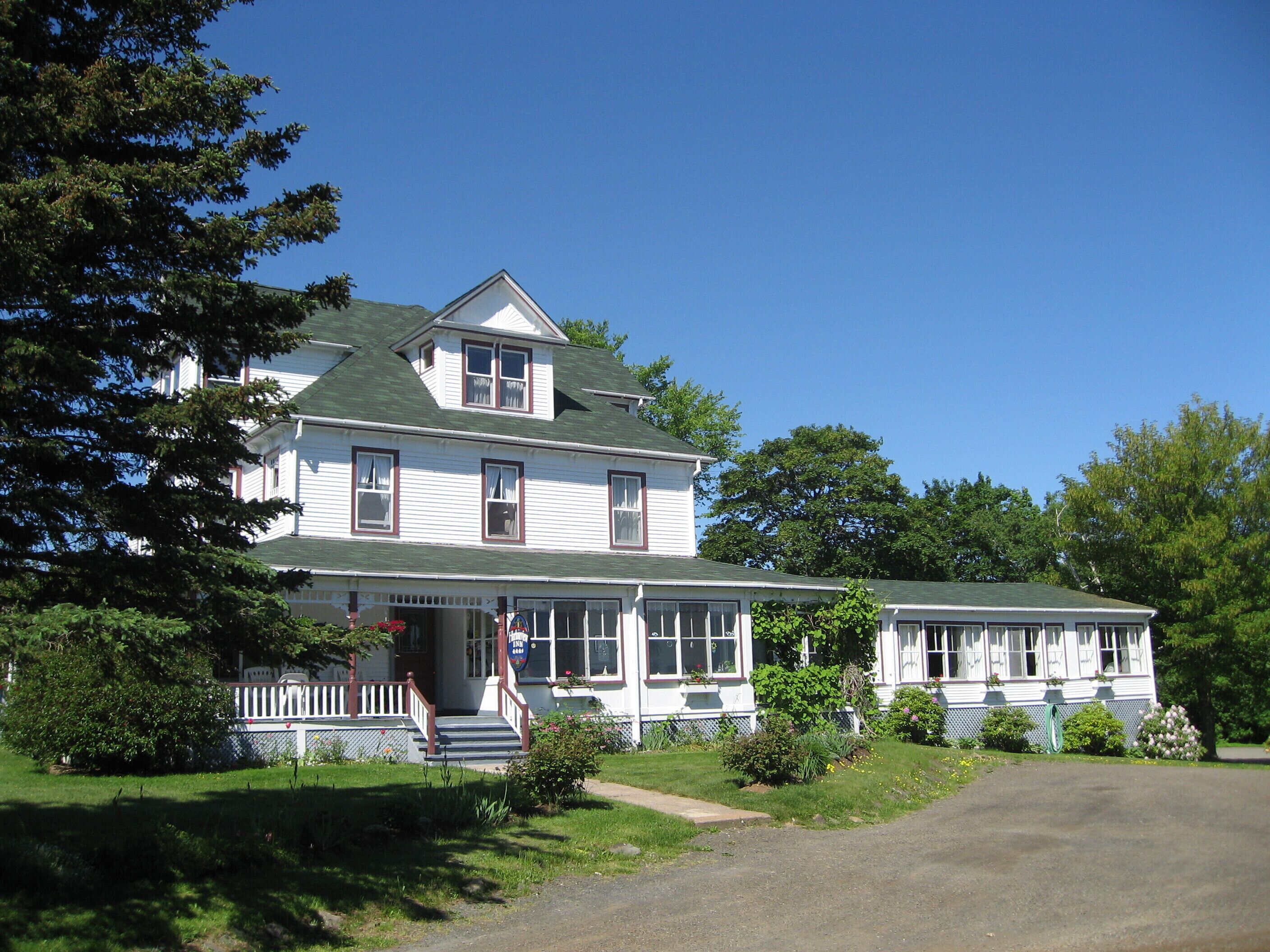 A two-story house with a porch, a front yard, and a driveway.