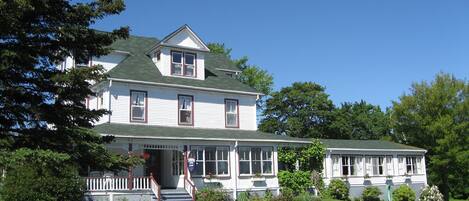 A two-story house with a porch, a front yard, and a driveway.