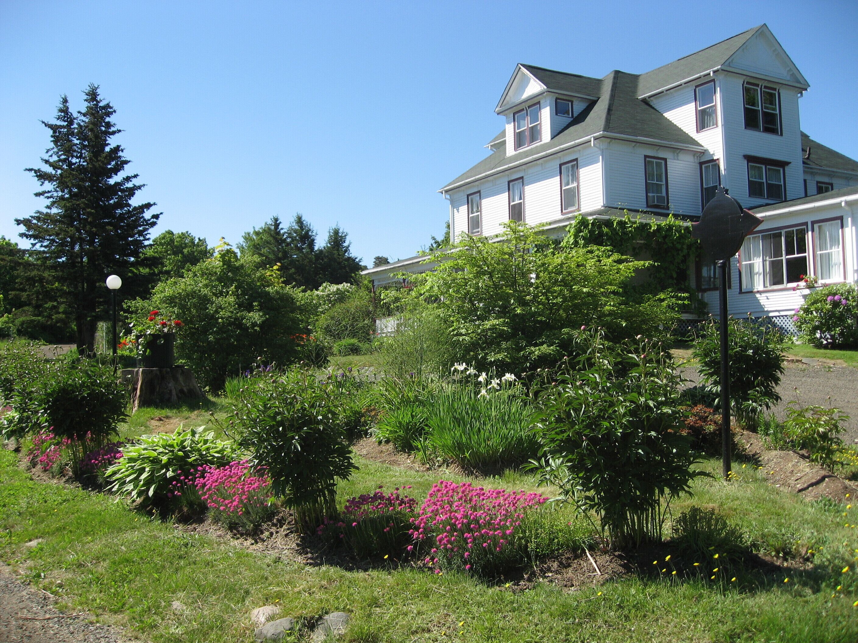 A large two-story house with a well-maintained garden in front.