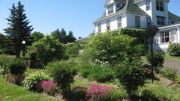 A large two-story house with a well-maintained garden in front.
