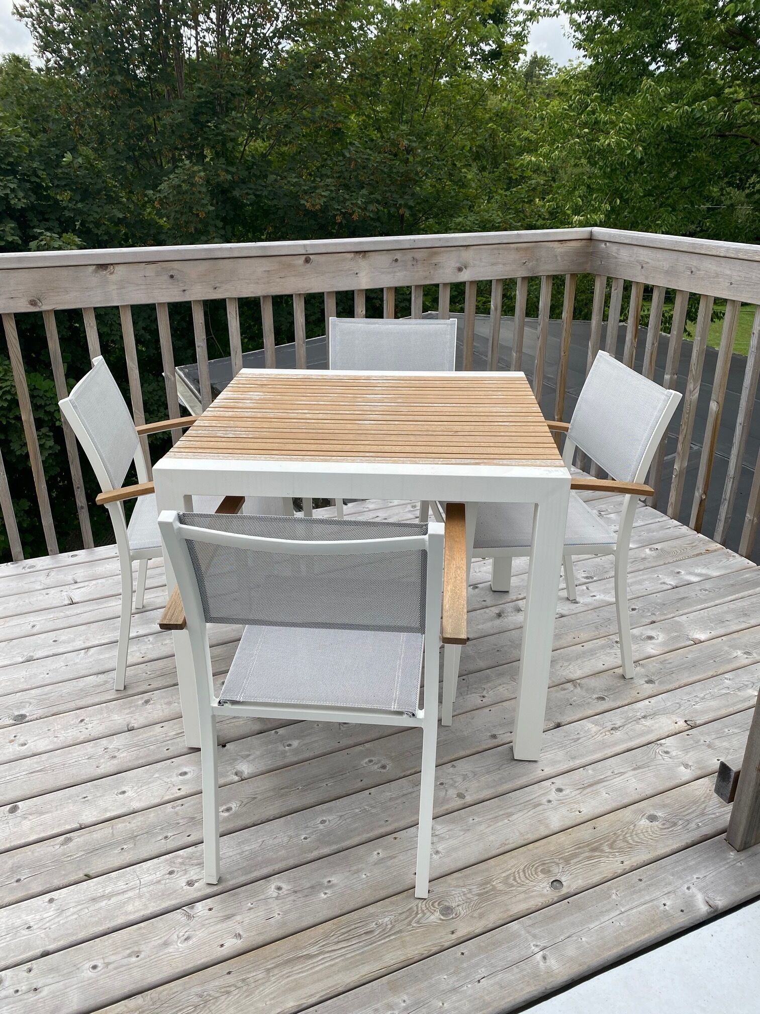 Una terraza de madera con una mesa y sillas.