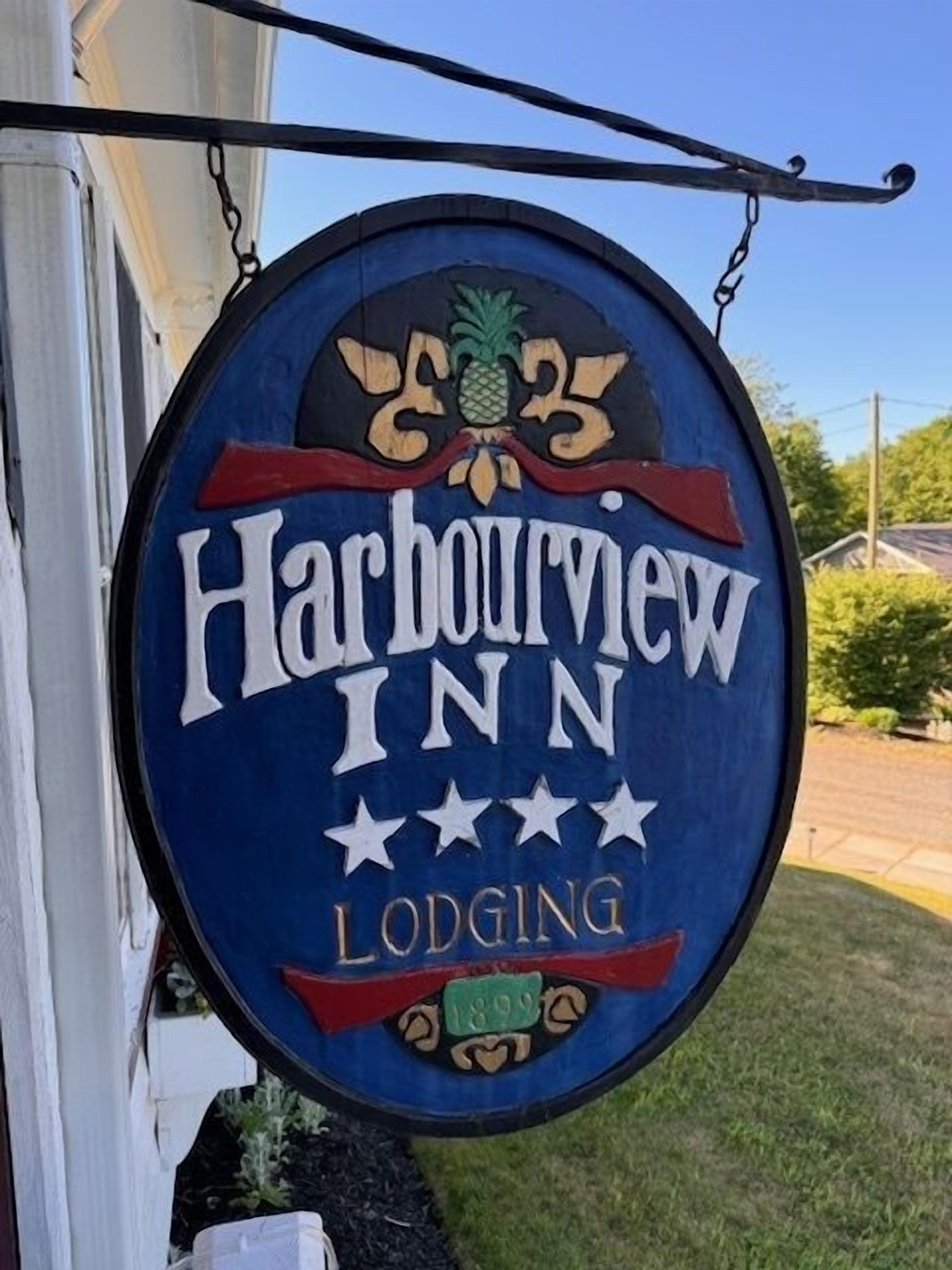 A circular sign with 'Harbourview Inn' and 'Lodging' text, a pineapple emblem, and a date stamp.