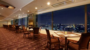 Un comedor de hotel con vista a la ciudad por la noche.
