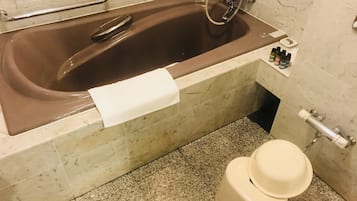 A bathroom with a bathtub, toilet, and a towel rack.