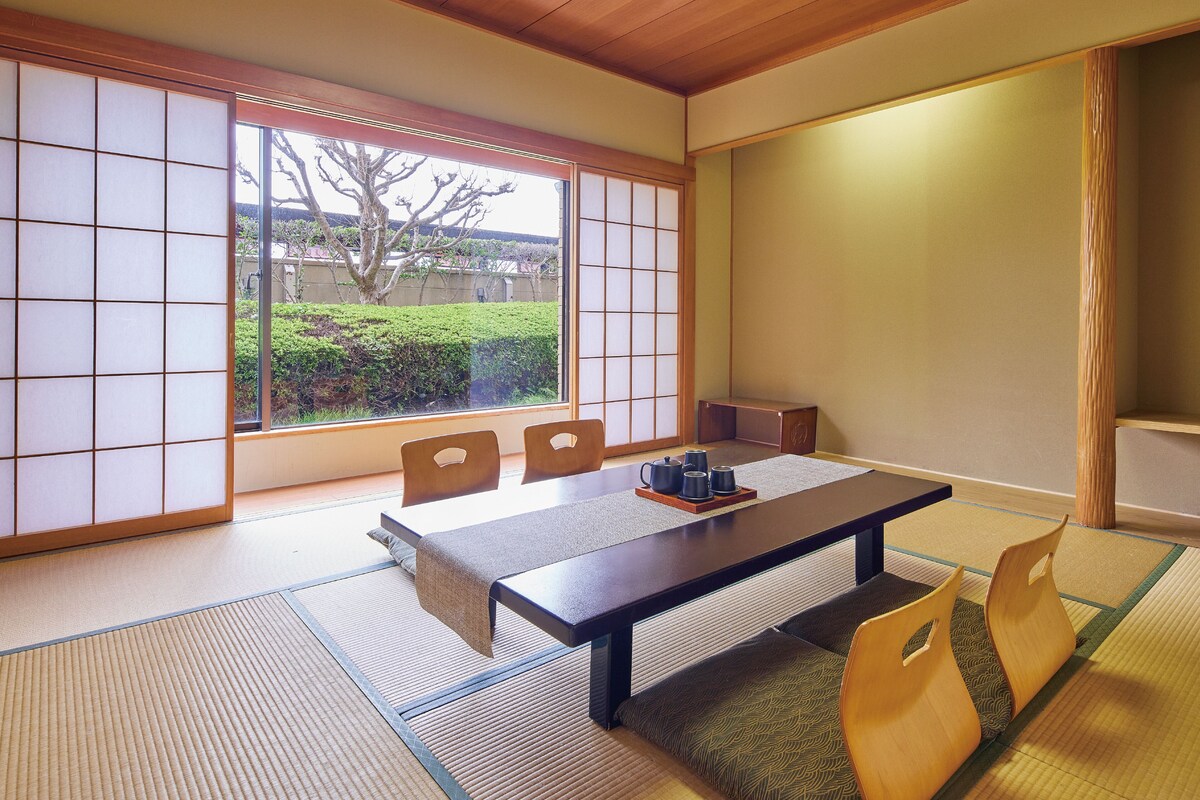 Une pièce de style japonais traditionnel, avec un sol recouvert de tatamis, une table basse et des portes coulissantes.