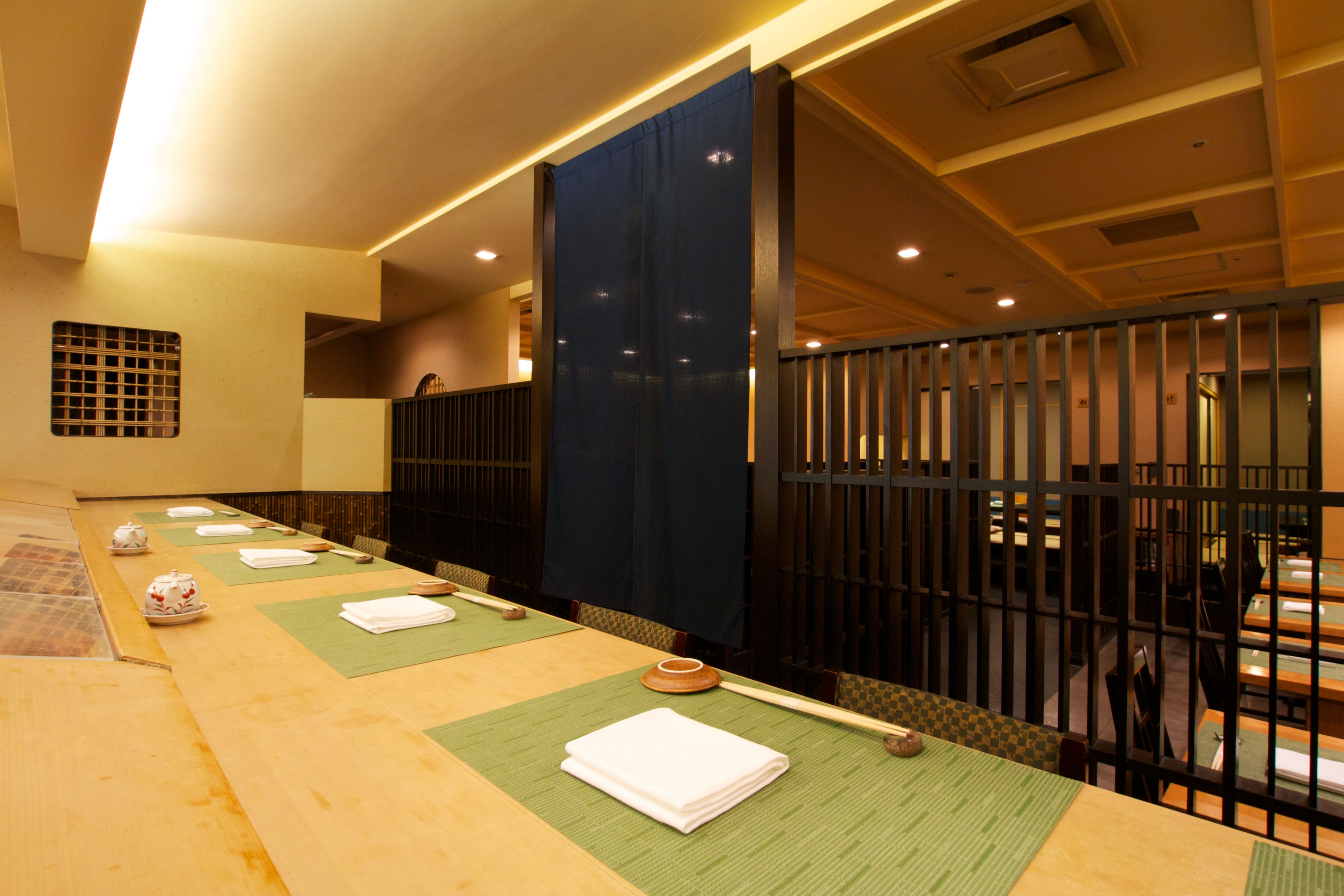 A traditional Japanese-style room with tatami mats, low tables, and shoji screens.