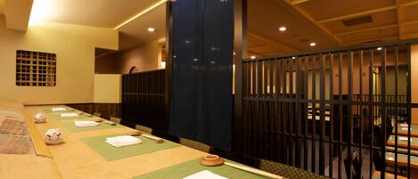 A traditional Japanese-style room with tatami mats, low tables, and shoji screens.