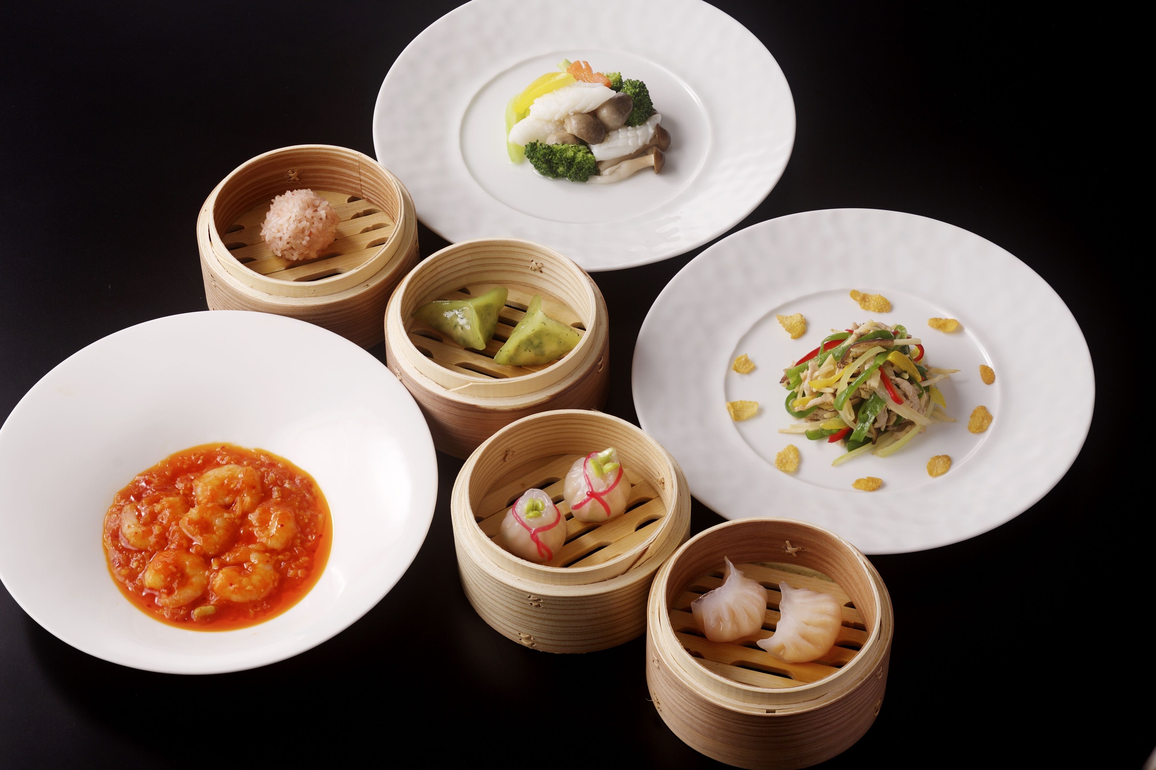 A variety of dishes including dumplings, a bowl of soup, and a plate with vegetables.