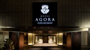 Entrada de un hotel con un cartel que dice "HOTEL AGORA osaka-moriguchi".