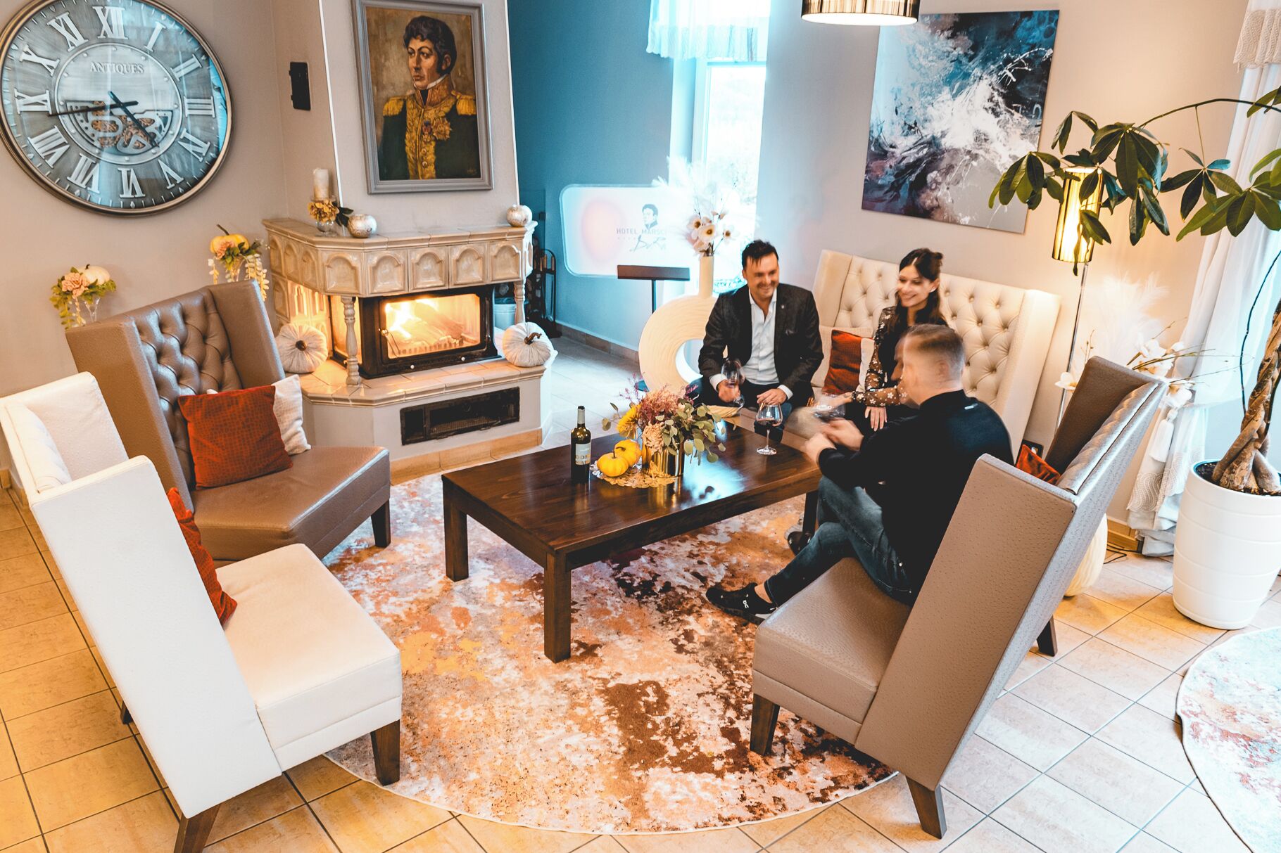A modern living room with a fireplace, comfortable seating, and a clock on the wall.