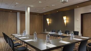 A conference room with a long table, chairs, water bottles, and glasses.
