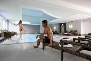A swimming pool area with lounge chairs and a couple by the pool. - Best Western Plus Hotel Willingen (Willingen)