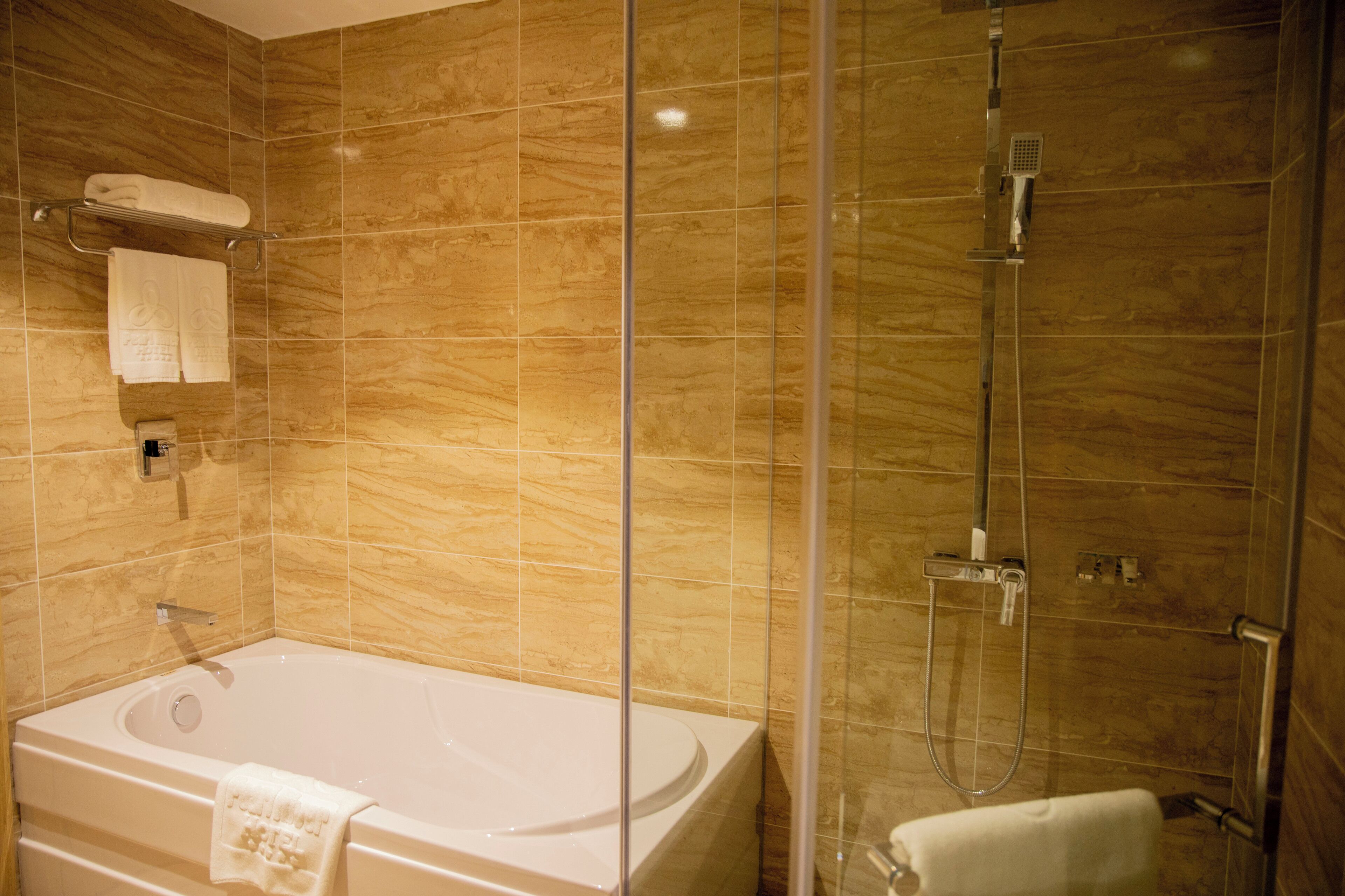 A bathroom with a bathtub, a shower, and a glass-enclosed shower area.