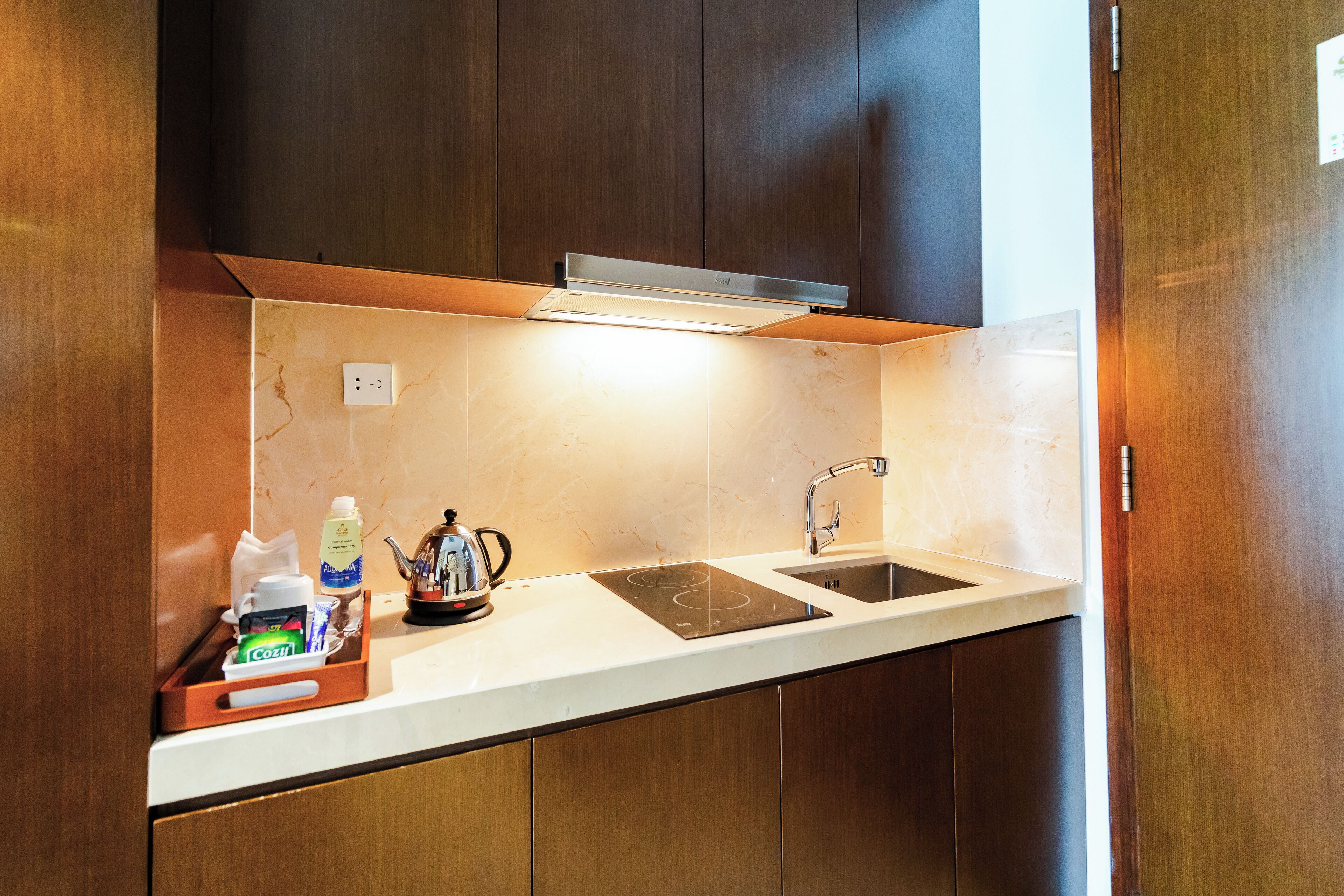 A modern kitchen with a built-in stove, sink, and overhead lighting.