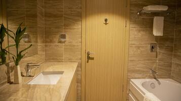 A modern bathroom with a wooden door, a sink, a bathtub, and a towel rack.