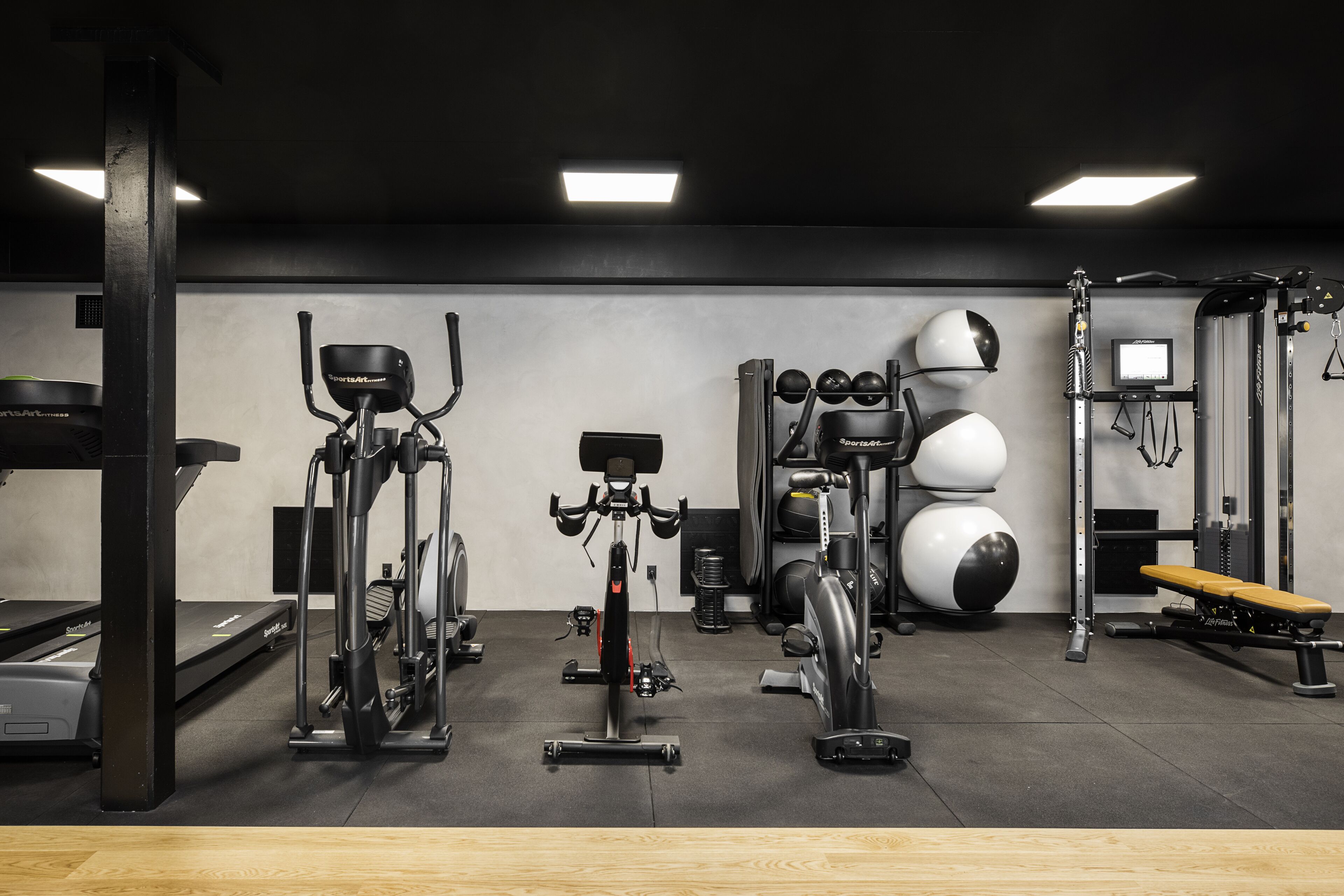 Una palestra con attrezzature per esercizi, un tapis roulant e una panca.