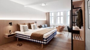 Un dormitorio moderno con una cama grande, mesitas de noche, una silla y un armario empotrado.