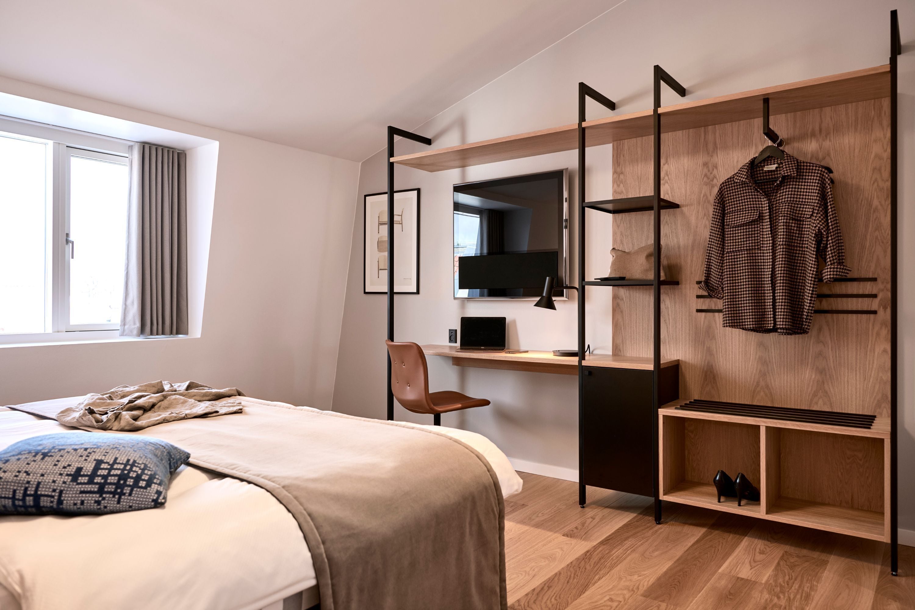 Une chambre à coucher moderne avec un lit, un bureau, une chaise et une armoire.