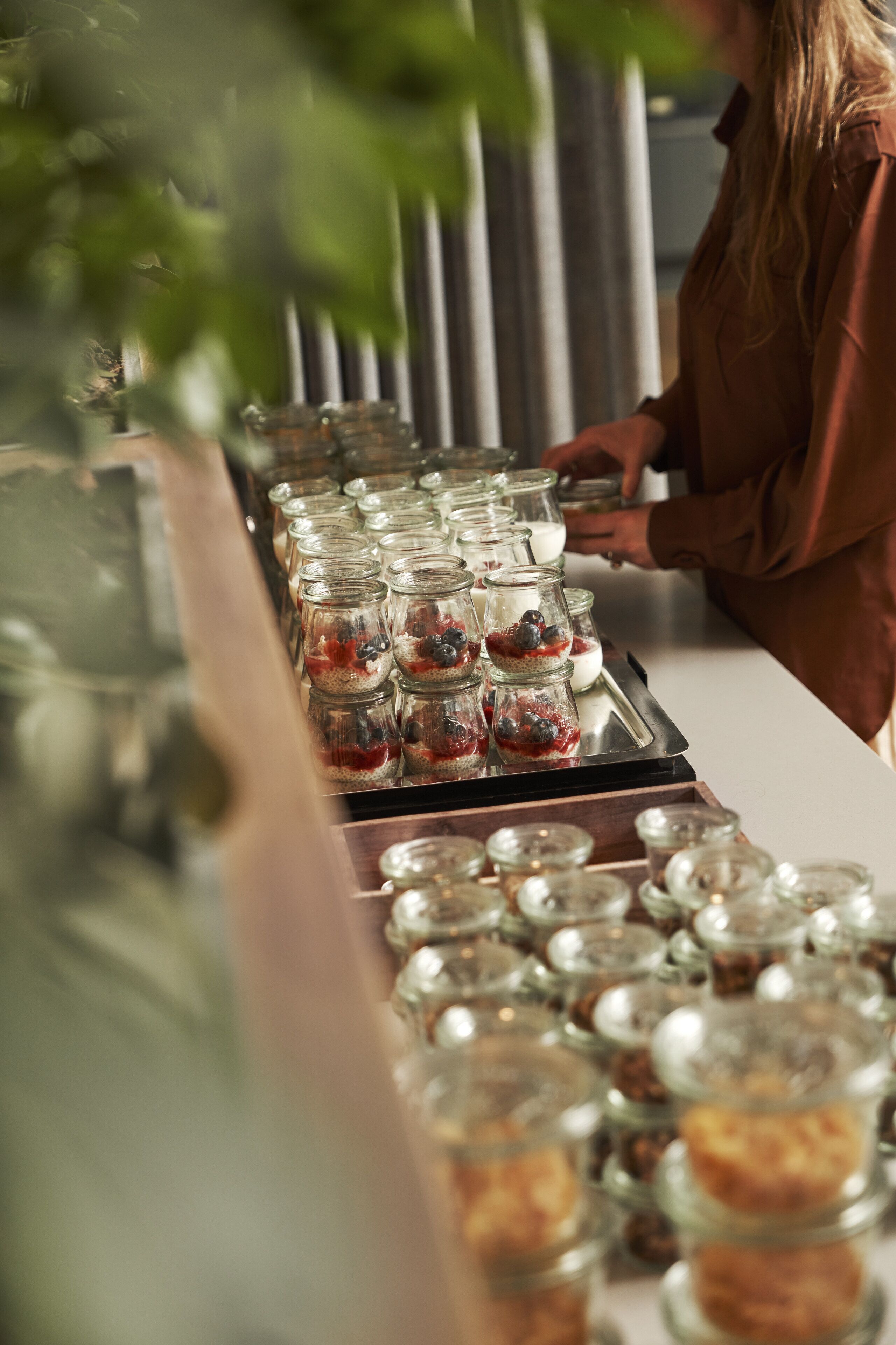 A buffet table with various food items in glass containers.