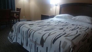 Una camera d'albergo con un letto, una scrivania e una sedia.