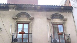 A building with two windows, each with a balcony and a flower box. - Bad - Bed & Breakfast and Design (Catania)