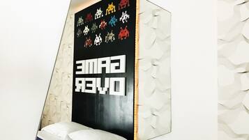 A room with a bed, a wall-mounted TV, and a decorative wall panel.